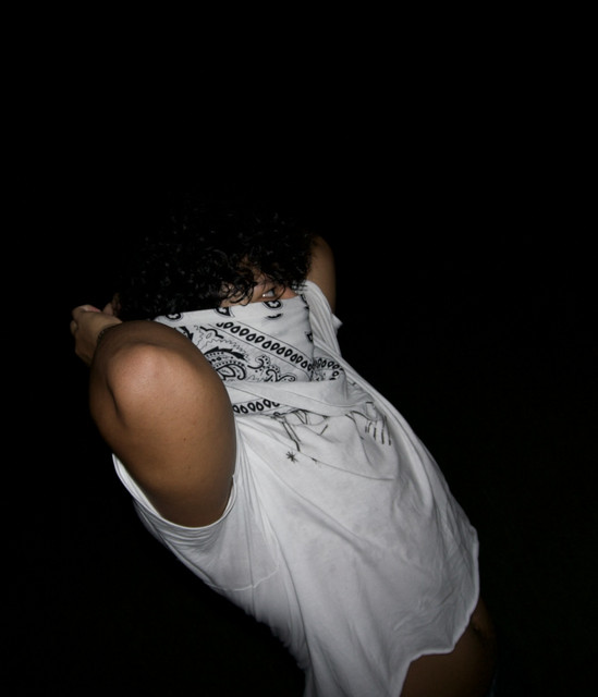 clive, photographed at night with a camera flash, a bandana pulled over his face